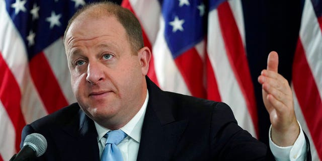 In this Nov. 24 photo, Colorado Gov. Jared Polis makes a point during a news conference in Denver about the state's response to the rapid increase in COVID-19 cases. Polis joined the nation's top infectious disease expert Dec. 1, and urged people to wear masks and socially distance to help prevent stay-at-home orders and overwhelmed hospitals as cases of the coronavirus surge during the holidays. (AP Photo/David Zalubowski, File)