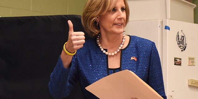 Republican Congresswoman Claudia Tenney signals she successfully cast her ballot after voting at St. George's Church in New Hartford, N.Y., on Nov. 6, 2018. (AP Photo/Heather Ainsworth, File)