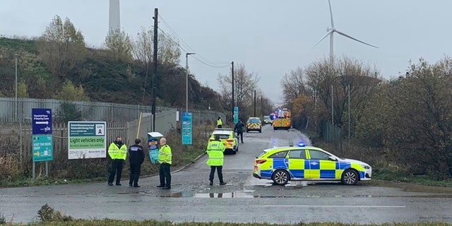 In this photo taken with permission from the Twitter feed of @jawadburhan98, police officers attend the scene of a "large" explosion, Thursday Dec. 3, 2020. A local emergency services department says fire and rescue workers are responding to a report of a “large” explosion at a port near the southwest England city of Bristol. (@Twitter/jawadburhan98 via AP)