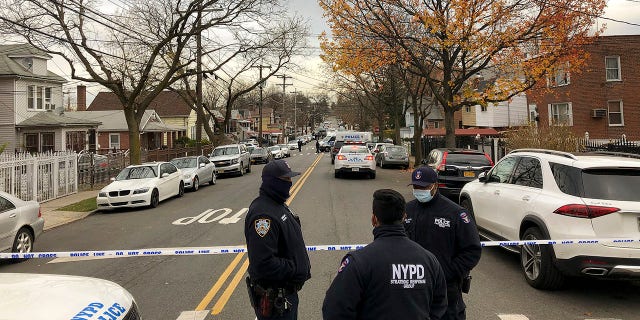 New York Police officers block off the street near the scene where a suspect was killed during a shootout with U.S. marshals in the Bronx that left two officers wounded, Friday, Dec. 4, 2020, in New York.. (AP Photo/Mark Lennihan)