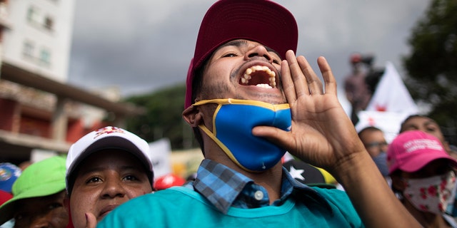 A government supporter shouts in support of parliamentary candidates representing the Great Patriotic Pole party at a closing campaign rally in Caracas, Venezuela, Thursday, Dec. 3, 2020. (AP Photo/Ariana Cubillos)