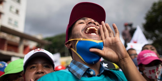 A government supporter shouts in support of parliamentary candidates representing the Great Patriotic Pole party at a closing campaign rally in Caracas, Venezuela, Thursday, Dec. 3, 2020. (AP Photo/Ariana Cubillos)