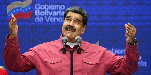 Venezuela's President Nicolas Maduro talks to journalists covering his vote in elections to choose members of the National Assembly in Caracas, Venezuela, Sunday, Dec. 6, 2020. The vote, championed by Maduro, is rejected as fraud by the nation's most influential opposition politicians. (AP Photo/Ariana Cubillos)