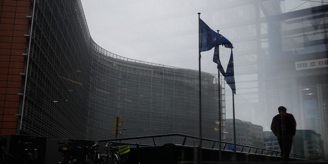 A pedestrian walk past the European Commission headquarters in Brussels, Dec.  7, 2020.