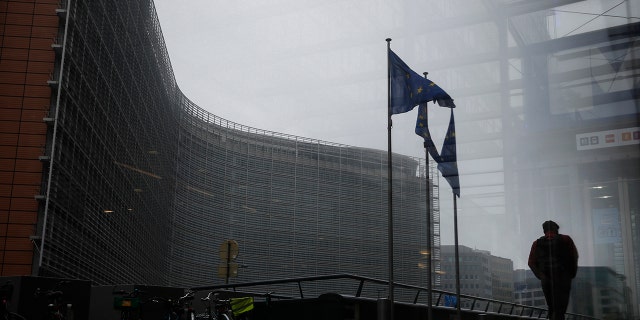 A pedestrian walks past the European Commission headquarters in Brussels, Dec. 7, 2020.