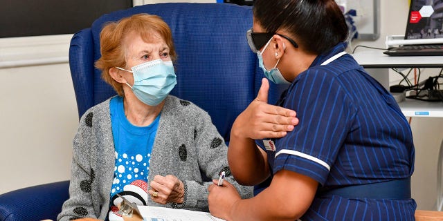 Nurse May Parsons prepares 90-year-old Margaret Keenan, the first patient in the UK to receive the Pfizer-BioNTech COVID-19 vaccine, at University Hospital, Coventry, England, Tuesday, Dec. 8, 2020.