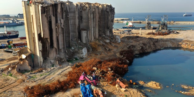 Rubble and debris remain around towering grain silos gutted in the massive August explosion at the Beirut port that claimed the lives of more than 200 people, in Beirut, Lebanon, Wednesday, Dec. 2, 2020. A heated debate is underway in Lebanon over the fate of the towering silos with some arguing the gutted silos could collapse at any moment and must be demolished, while others call for the ruins to be preserved as a grim memorial. (AP Photo/Hussein Malla)