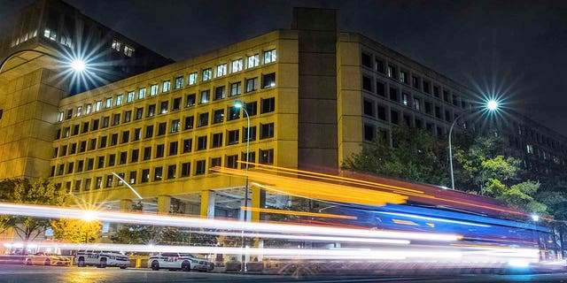 Traffic along Pennsylvania Avenue in Washington, D.C., streaks past the Federal Bureau of Investigation headquarters on Nov. 1, 2017. (AP Photo/J. David Ake, File)