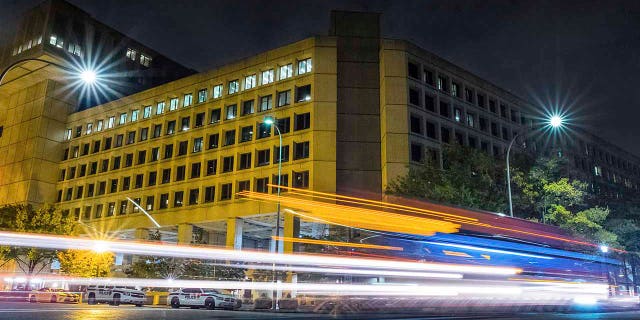 Traffic along Pennsylvania Avenue in Washington, D.C., streaks past the Federal Bureau of Investigation headquarters on Nov. 1, 2017. (AP Photo/J. David Ake, File)