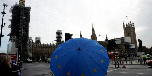 Pro-European Union membership supporters demonstrate by Parliament Square, with a scaffolded Houses of Parliament and the Elizabeth Tower, known as Big Ben in the background, in London, Wednesday, Dec. 9, 2020. British Prime Minister Boris Johnson will fly to Brussels later Wednesday in an attempt to reach a breakthrough on a Brexit trade deal over dinner with Ursula von der Leyen, President of the European Commission. (AP Photo/Matt Dunham)