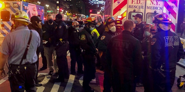 Emergency personnel at an intersection where pedestrians were struck by a car during a protest Friday, Dec. 11, 2020, in New York. The New York Fire Department says six people were hospitalized. (AP Photo/David Martin)