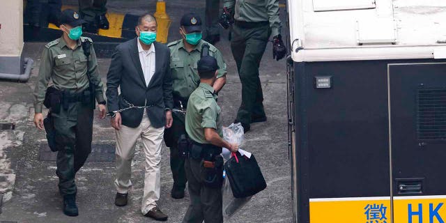 Hong Kong pro-democracy activist and media tycoon Jimmy Lai is escorted by Correctional Services officers to get on a prison van before appearing in a court, in Hong Kong, Saturday, Dec. 12, 2020. Lai, who founded the Apple Daily tabloid, has been charged under the city’s national security law, amid a widening crackdown on dissent, according to local media reports. (AP Photo/Kin Cheung)