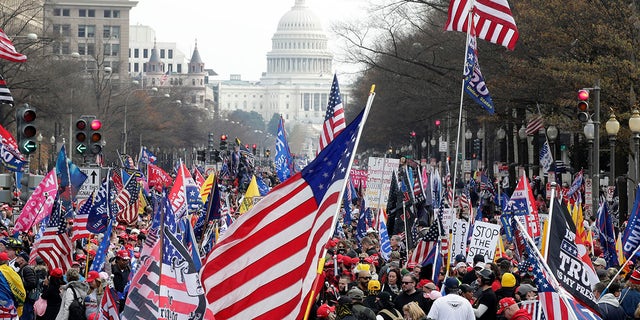 With the U.S. Capitol building in the background, supporters of President Donald Trump stand Pennsylvania Avenue during a rally at Freedom Plaza, Saturday, Dec. 12, 2020, in Washington. (AP Photo/Luis M. Alvarez)