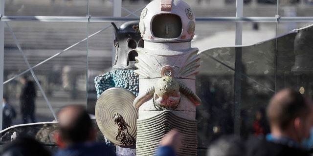 Faithful stop by the nativity scene as they wait for the start of Pope Francis'Angelus noon prayer in St. Peter's Square, at the Vatican, Sunday, Dec.13, 2020. (AP Photo/Gregorio Borgia)
