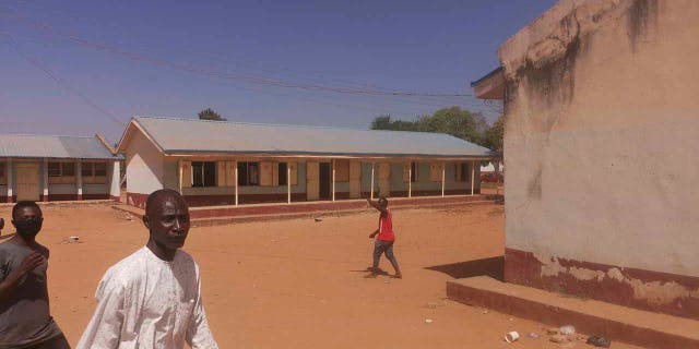 People gather inside the Government Science Secondary School in Kankara, Nigeria, Saturday, Dec. 12, 2020. Nigerian police say that hundreds of students are missing after gunmen attacked the secondary school in the country’s northwestern Katsina state. (AP Photo/Abdullatif Yusuf)