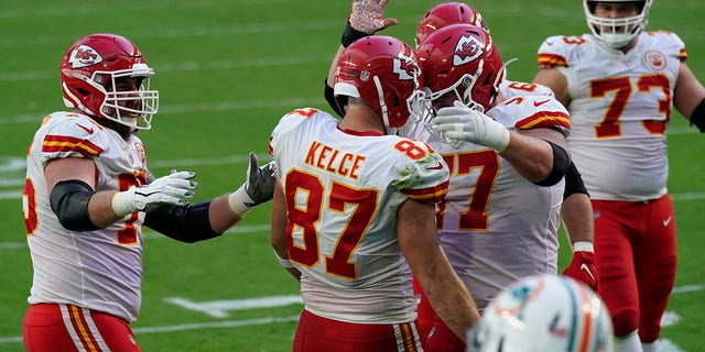 Kansas City Chiefs tight end Travis Kelce (87) is congratulated by his teammates after scoring a touchdown during the first half of an NFL football game against the Miami Dolphins, Sunday, Dec. 13, 2020, in Miami Gardens, Fla. (AP Photo/Lynne Sladky)