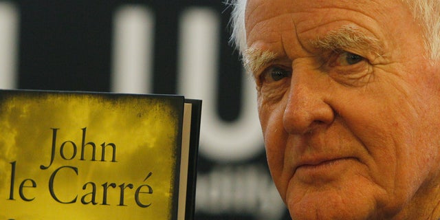 British author John le Carre holds a copy of his new book entitled 'Our Kind of Traitor' at a central London bookstore during a book signing event to mark the launch of the novel in London Thursday, Sept. 16, 2010. (AP Photo/Alastair Grant, file)