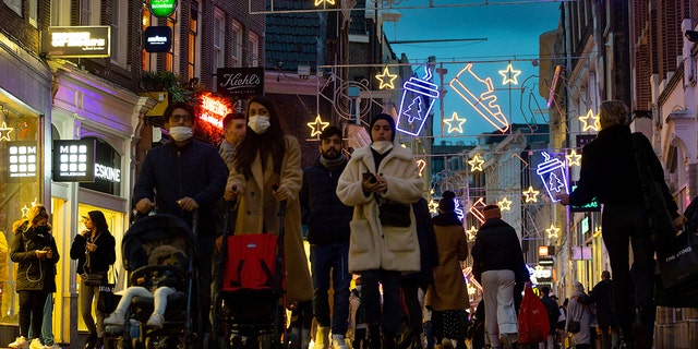 Shoppers walk down Kalverstraat in Amsterdam, Netherlands, Monday, Dec. 14, 2020. (AP Photo/Peter Dejong)