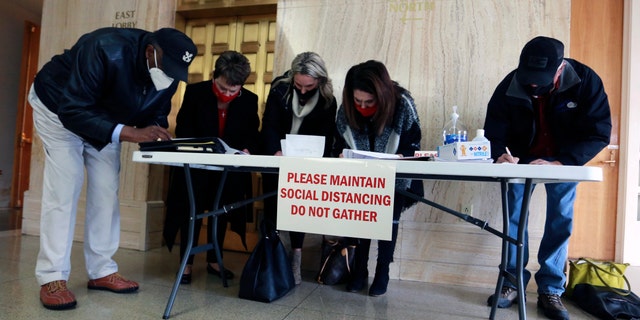Five self-proclaimed GOP electors hold an unofficial ceremony to endorse the reelection of President Donald Trump, Monday, Dec. 14, 2020, in the lobby of the Capitol building in Santa Fe, N.M. The meeting took place as the official electors cast the state's five electoral votes for Joe Biden in a closed meeting upstairs. (AP Photo/Cedar Attanasio)