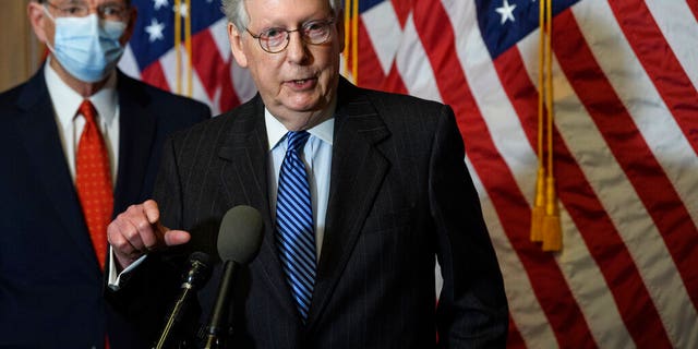 Senate Majority Leader Mitch McConnell of Ky., speaks during a news conference with other Senate Republicans on Capitol Hill in Washington, Tuesday, Dec. 15, 2020. Sen. John Barrasso, R-Wyo., listens at left. (Nicholas Kamm/Pool via AP)