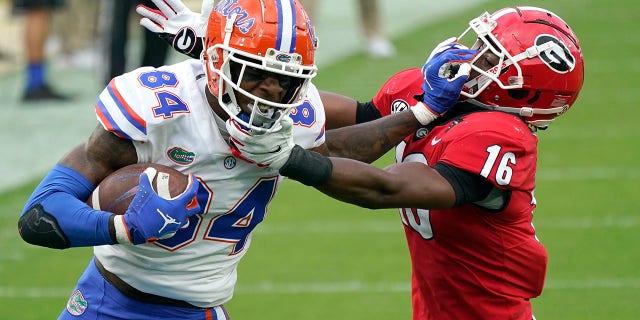 Florida tight end Kyle Pitts (84) tries to get past Georgia defensive back Lewis Cine (16) after a reception during the first half of an NCAA college football game in Jacksonville, Fla., in this Saturday, Nov. 7, 2020, file photo. (AP Photo/John Raoux, File)