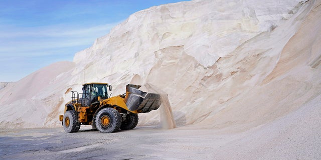 A front loader works at a large pile of road salt, Wednesday, Dec. 16, 2020, in Chelsea, Mass., as preparation continues for a storm that is expected to dump a foot or more of snow throughout the Northeast. (AP Photo/Elise Amendola)
