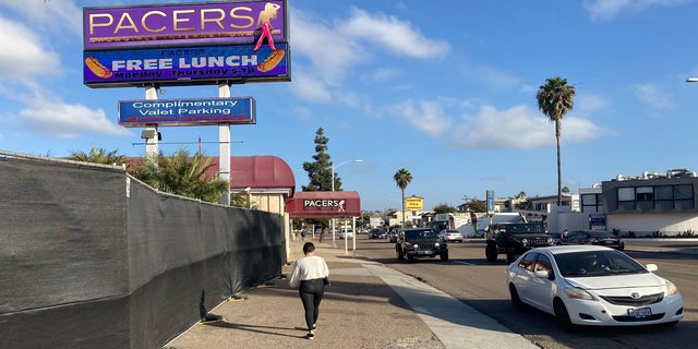 In this Dec. 10, 2020, file photo, a person walks past Pacers Showgirls International in San Diego. (AP Photo/Elliot Spagat, File)