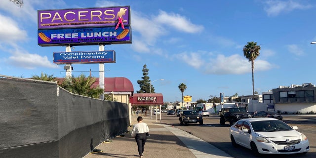 In this Dec. 10, 2020, file photo, a person walks past Pacers Showgirls International in San Diego. (AP Photo/Elliot Spagat, File)