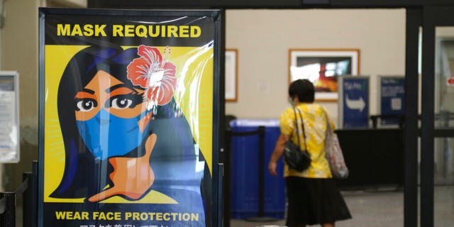 A woman walks into the international airport in Honolulu amid a quarantine rule that effectively shut down the tourism industry in the state. 