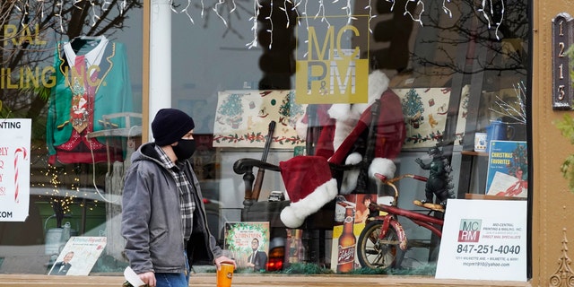 Christmas cards and costumes are displayed in the window at Mid Central Printing &安培; Mailing store in Wilmette, 生病。, 星期五, 十二月. 18, 2020. (AP Photo/Nam Y. Huh)