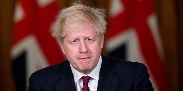 Britain's Prime Minister Boris Johnson speaks during a news conference in response to the ongoing situation with the coronavirus (COVID-19) pandemic, inside 10 Downing Street, London, Saturday, Dec. 19, 2020. Johnson says Christmas gatherings can’t go ahead and nonessential shops must close in London and much of southern England as he imposed a new, higher level of coronavirus restrictions to curb rapidly spreading infections. (Toby Melville/Pool Photo via AP)