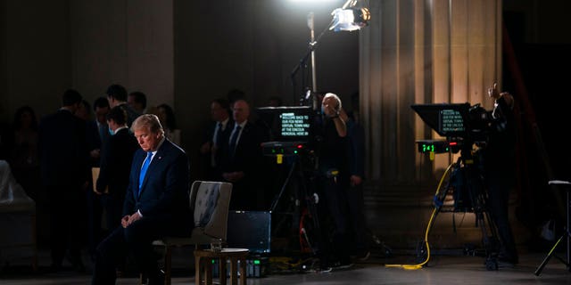 FILE: President Donald Trump waits for a segment to start during a Fox News virtual town hall from the Lincoln Memorial in Washington. 