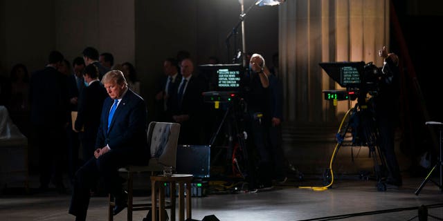 FILE: President Donald Trump waits for a segment to start during a Fox News virtual town hall from the Lincoln Memorial in Washington. 