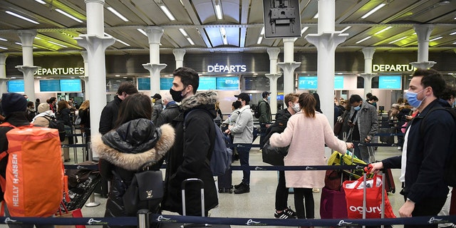 People at St. Pancras station in London, wait to board the last train to Paris on Sunday, Dec. 20, 2020. Millions of people in England have learned they must cancel their Christmas get-togethers and holiday shopping trips. British Prime Minister Boris Johnson said Saturday that holiday gatherings can’t go ahead and nonessential shops must close in London and much of southern England. (Stefan Rousseau/PA via AP)