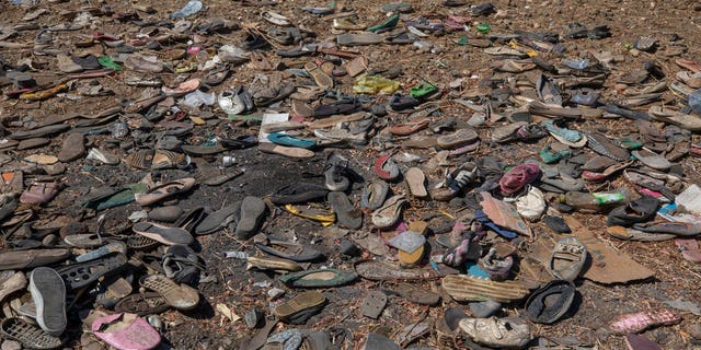 Shoes left behind belonging to Tigrayan refugees are scattered near the banks of the Tekeze River on the Sudan-Ethiopia border after Ethiopian forces blocked people from crossing into Sudan, in Hamdayet, eastern Sudan, Tuesday, Dec. 15, 2020. (AP Photo/Nariman El-Mofty)
