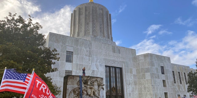 Protesters hold a rally outside the Oregon State Capitol in Salem, Ore. on Monday, Dec. 21, 2020, as legislators meet for a special session to discuss COVID-19 relief measures. (AP Photo/Sara Cline)