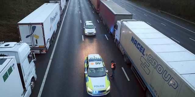 Police patrol along the M20 motorway where freight traffic is halted whilst the Port of Dover remains closed, in Ashford, Kent, England, Tuesday, Dec. 22, 2020. (Andrew Matthews/PA via AP)