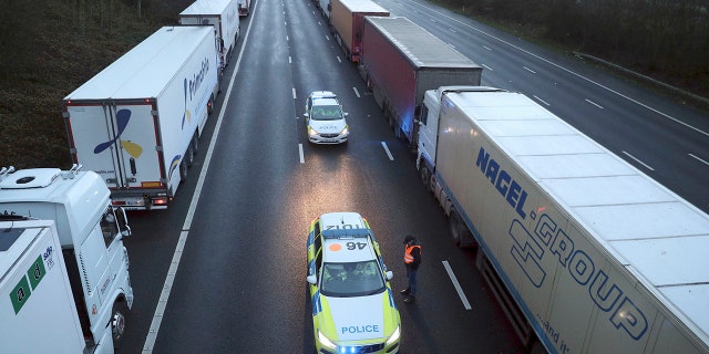 Police patrol along the M20 motorway where freight traffic is halted whilst the Port of Dover remains closed, in Ashford, Kent, England, Tuesday, Dec. 22, 2020. (Andrew Matthews/PA via AP)