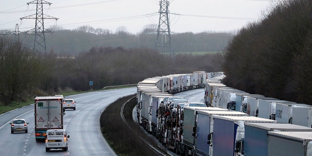 Trucks are parked along the M20 motorway where freight traffic is halted whilst the Port of Dover remains closed, in Ashford, Kent, England, Tuesday, Dec. 22, 2020.  (Andrew Matthews/PA via AP)
