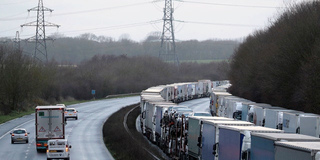 Trucks are parked along the M20 motorway where freight traffic is halted whilst the Port of Dover remains closed, in Ashford, Kent, England, Tuesday, Dec. 22, 2020. (Andrew Matthews/PA via AP)