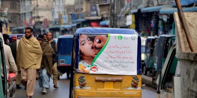 An auto rickshaw with a poster advertising a polio campaign drives through a market in Peshawar, Pakistan. Pakistan, Afghanistan and Nigeria are the only countries in the world where polio is still endemic. Lack of trust in vaccinations is one of many obstacles that will face public health officials in poor and developing countries as they seek to vaccinate millions of people against COVID-19. (AP Photo/Muhammad Sajjad)