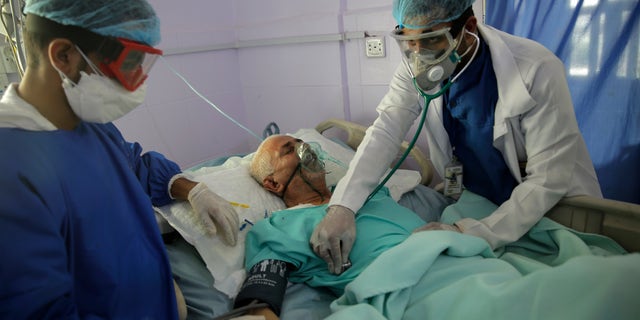 FILE - In this June 14, 2020, file photo, medical workers attend to a COVID-19 patient in an intensive care unit at a hospital in Sanaa, Yemen. The task of vaccinating millions of people in poor and developing countries against COVID-19 faces monumental obstacles, and it's not just a problem of affording and obtaining doses. In Yemen, the health system has collapsed under six years of war between Houthi rebels who control the north and government-allied factions in the south. (AP Photo/Hani Mohammed, File)