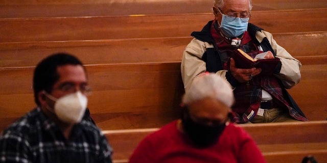 Worshipers gather for a Christmas Eve Mass inside a Los Angeles church. (AP Photo/Ashley Landis)