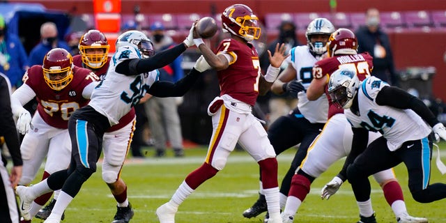 Carolina Panthers defensive end Marquis Haynes (98) puts his hand on the ball as Washington Football Team quarterback Dwayne Haskins (7) passes during the first half of an NFL football game, Sunday, Dec. 27, 2020, in Landover, Md. (AP Photo/Carolyn Kaster)