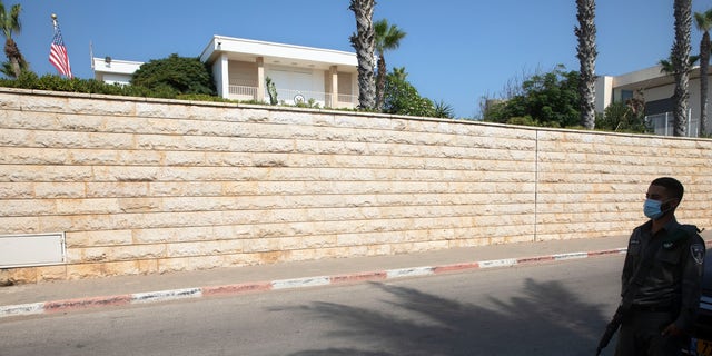 In this September 2020 file photo, an Israeli border police officer stands guard next to the U.S. ambassador's official residence in a suburb of Tel Aviv. An official record shows that the United States sold the ambassador’s residence in Israel for more than $  67 million in July. (AP Photo/Sebastian Scheiner, File)