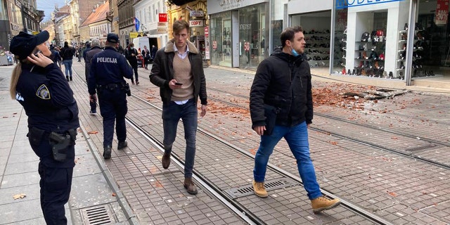 I residenti camminano accanto ai detriti causati da un terremoto nel centro di Zagabria, Croazia, martedì, Dic. 29, 2020. Martedì un forte terremoto ha colpito la Croazia, con alcuni feriti riportati oltre a notevoli danni a tetti ed edifici a sud-est della capitale. (AP Photo / Filip Horvat)