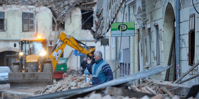 A man stands amidst the rubble from buildings damaged in an earthquake in Petrinja, Croatia, Tuesday, Dec. 29, 2020. A strong earthquake has hit central Croatia and caused major damage and at least one death and some 20 injuries in the town southeast of the capital Zagreb. (AP Photo)