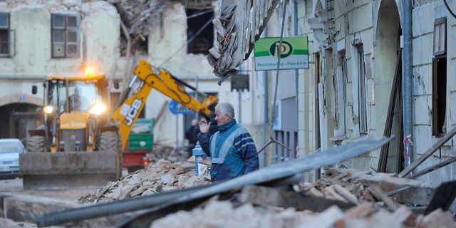 A man stands amidst the rubble from buildings damaged in an earthquake in Petrinja, Croatia, Tuesday, Dec. 29, 2020. A strong earthquake has hit central Croatia and caused major damage and at least one death and some 20 injuries in the town southeast of the capital Zagreb. (AP Photo)