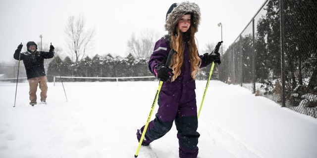 Isabel Wang, 8, cross-country skied home through Scheid Park in Golden Valley, 敏恩, with her younger brother, Fearghus, 4 and father, Hans, during the snowstorm on Tuesday, 十二月. 29, 2020. (Aaron Lavinsky/Star Tribune via AP)