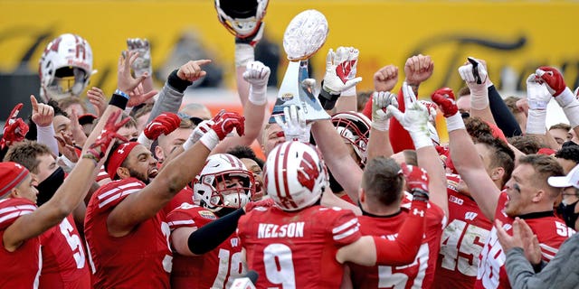 Wisconsin players hoist the trophy following victory over Wake Forest in the Duke's Mayo Bowl NCAA college football game at Bank of America Stadium in Charlotte, N.C., Wednesday, Dec. 30, 2020. (Associated Press)